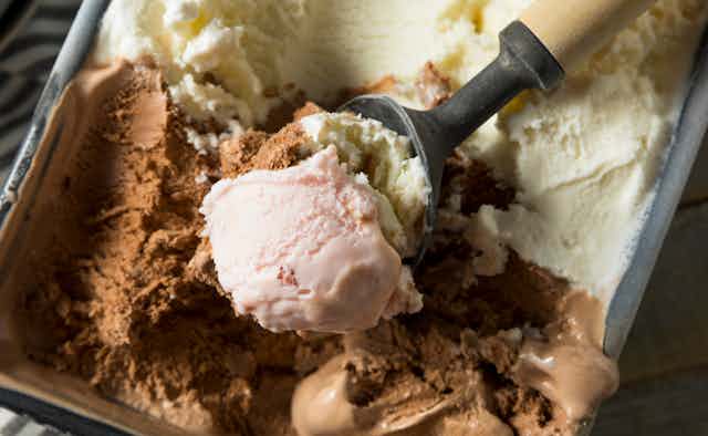 Close up scoop of neapolitan ice cream with pink visible on top