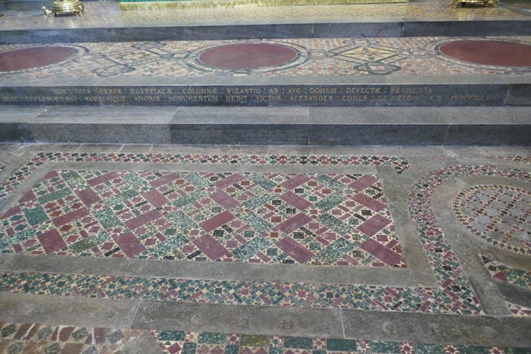 A close-up of an inscription on a mosaic floor.