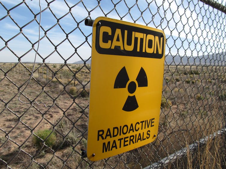 fence with a CAUTION RADIOACTIVE MATERIAL sign