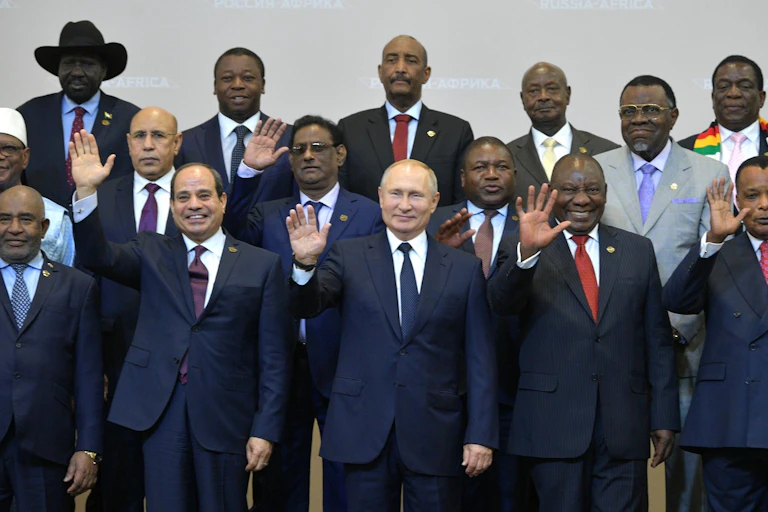 Men waving in a group photograph.