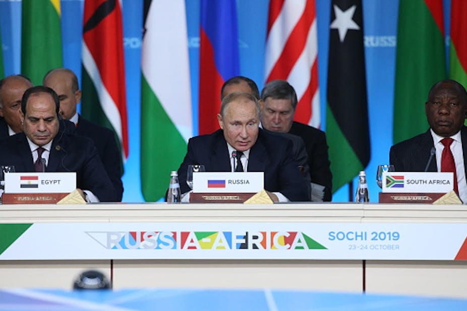  Three male presidents wearing ties address a press conference behind a desk with the sign Russia-Africa, Sochi 2019.