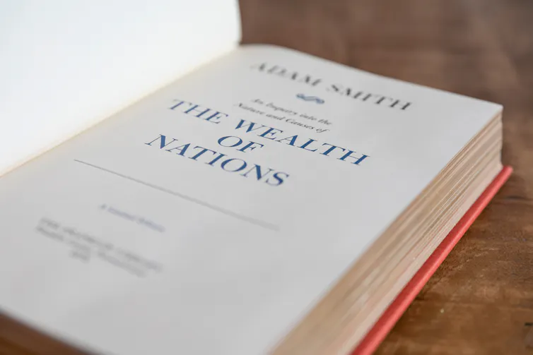Image of book open to title page that says Adam Smith and The Wealth of Nations.