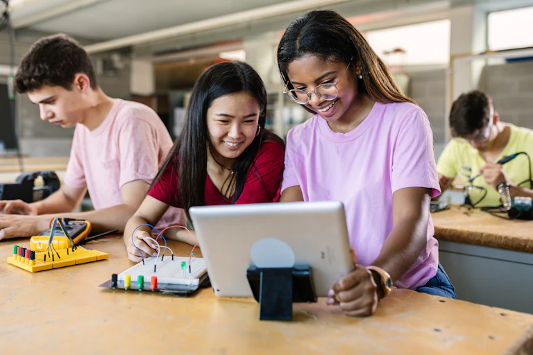 School students in own clothes working on electrical circuit