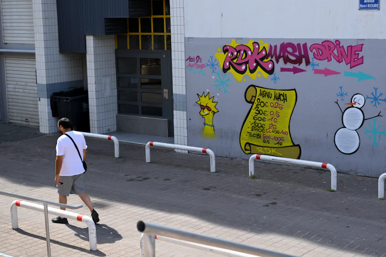 Un passant marche devant un point de deal à la Cité de la Castellane dans le nord de Marseille, 27 juin 2023.