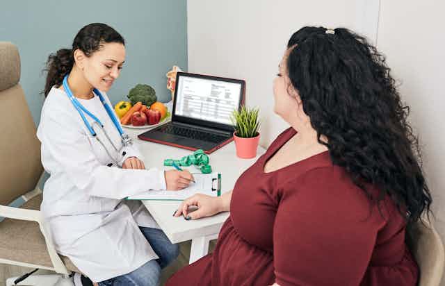 Une patiente avec un surplus de poids discute avec sa médecin.