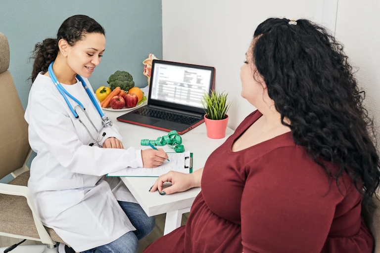 Une patiente avec un surplus de poids discute avec sa médecin.