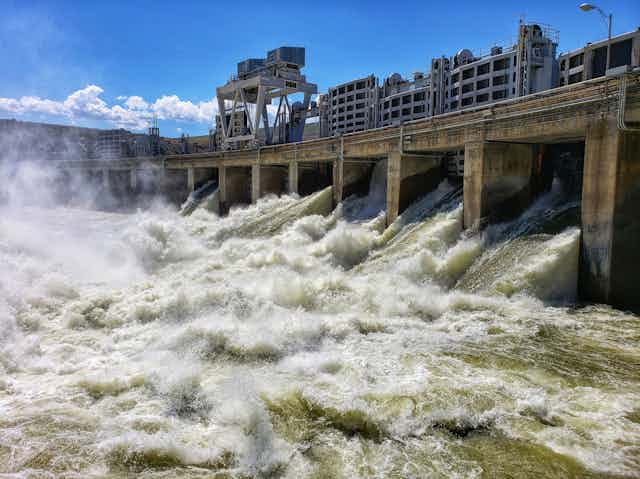 Water pours out of the gates of a dam. 