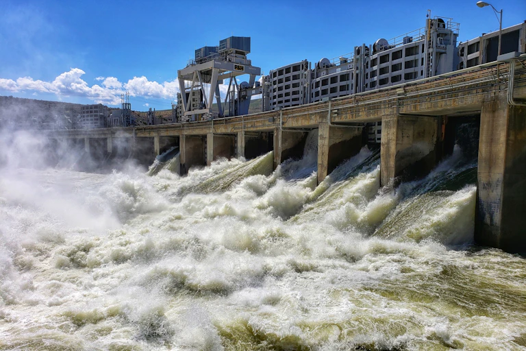 Water pours out of the gates of a dam.