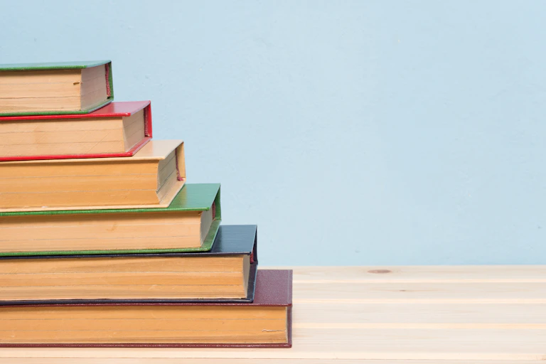 A pile of hardcover books, arranged like steps.