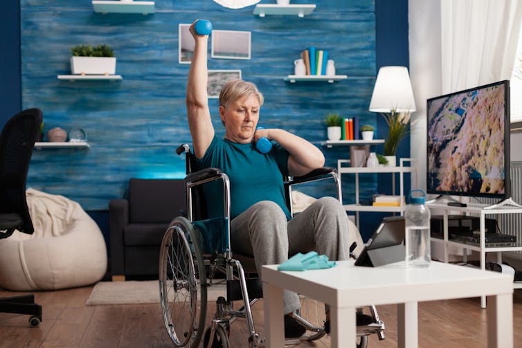Woman in wheelchair lifts weights