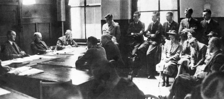 Crowded courtroom with two conscientious objectors at the centre,