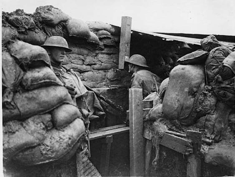 British soldier looks through a trench periscope at the Western Front.