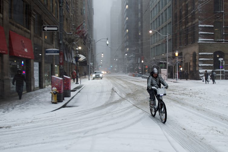 A cyclist rides their bike during a snow storm in Toronto.