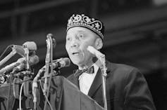 Elijah Muhammad speaks at a conference.