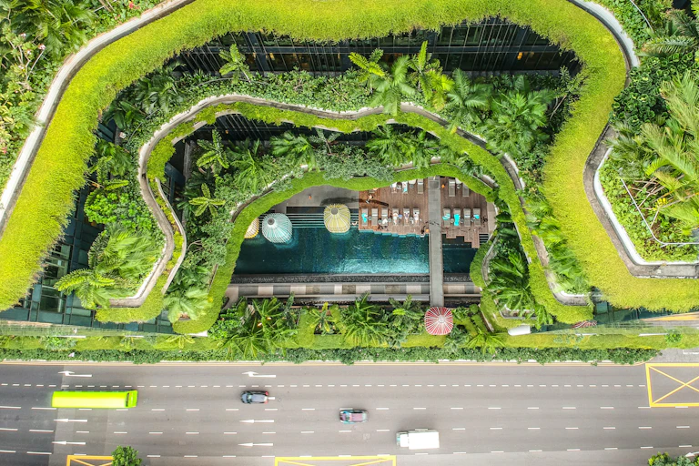 Vista desde arriba de varias terrazas pobladas de plantas y una piscina en el suelo.