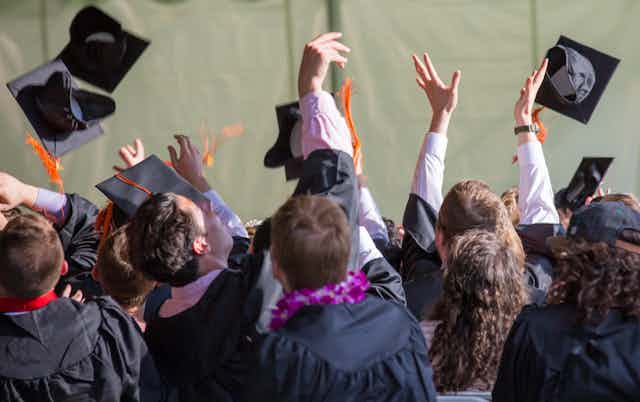 People seen throwing graduation hats in the air.