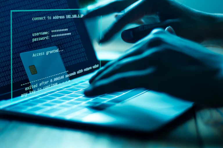 A pair of hands types on a laptop computer.