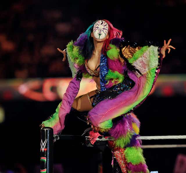Asuka in a mask and colourful robe.