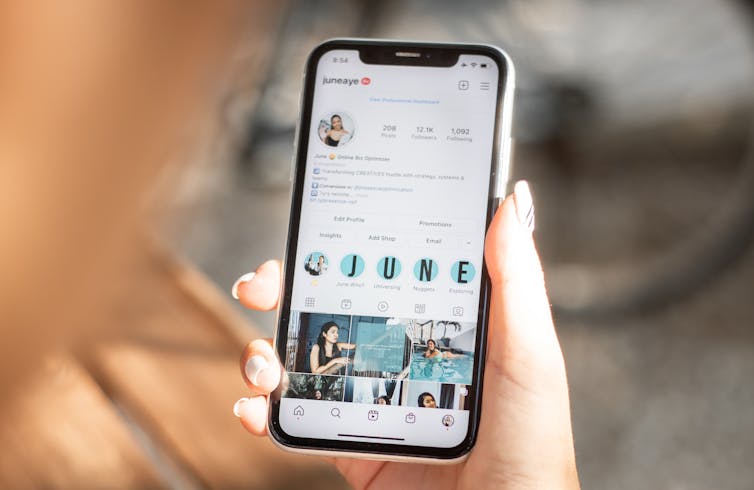 A hand holding a phone open on Instagram