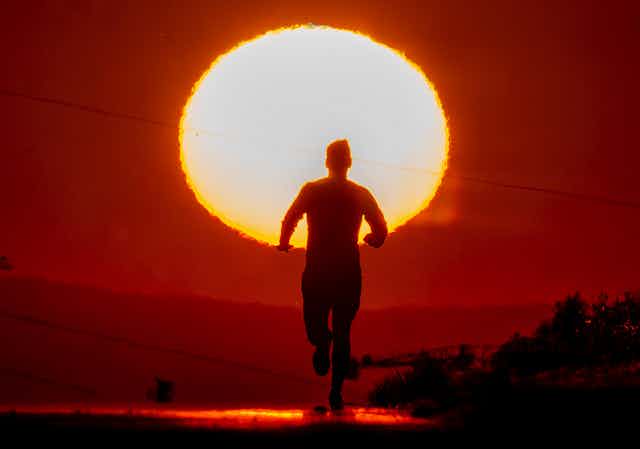 A person runs under a  hot sun