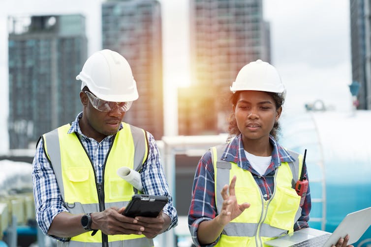 Two people in hard hats outside