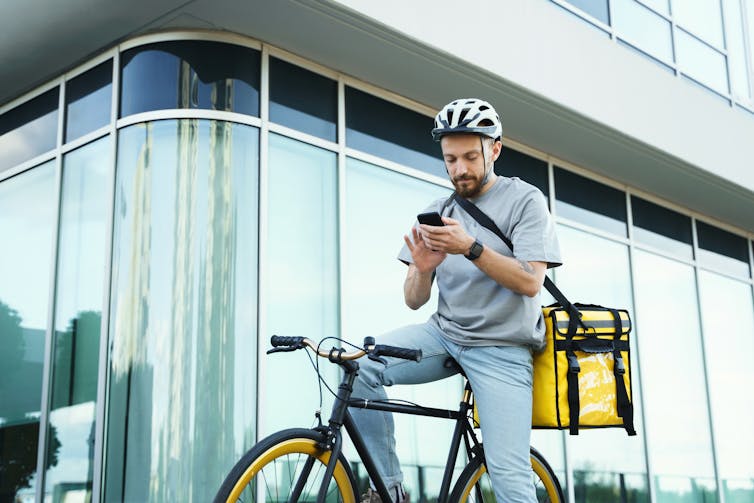 Express food delivery courier riding a bicycle with an insulated bag on his back