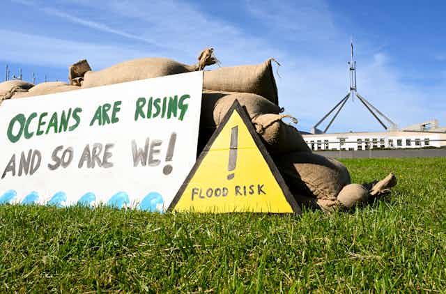A replica seawall build from sandbags by Traditional Owners from the Torres Strait is seen during a rally calling for stronger action on climate change outside Parliament House in Canberra, Monday, November 7, 2022.