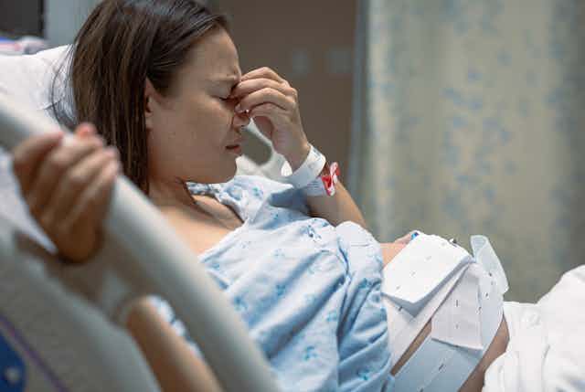Pregnant woman in hospital looks unhappy
