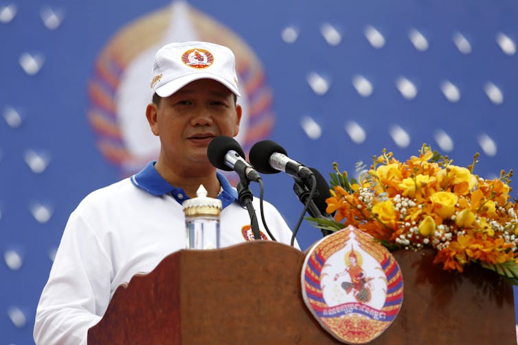 Cambodian politician Hun Manet makes a speech dressed in the white uniform of the Cambodia People's Party.