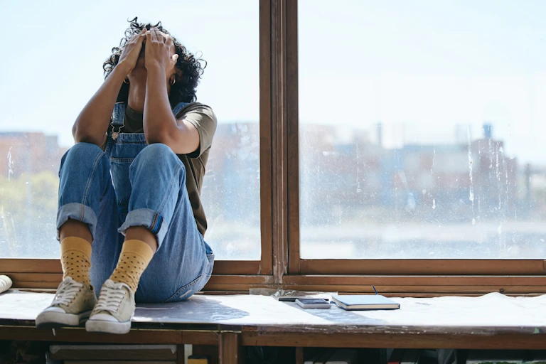 A distressed student covers her face.
