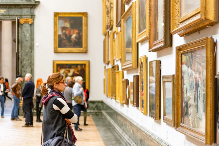 A woman looks at a painting in a gallery