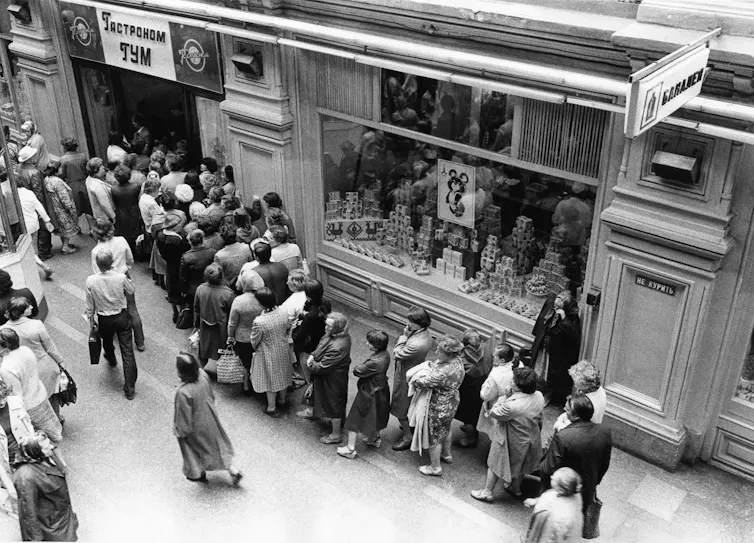 An archival photograph of a queue of shoppers.