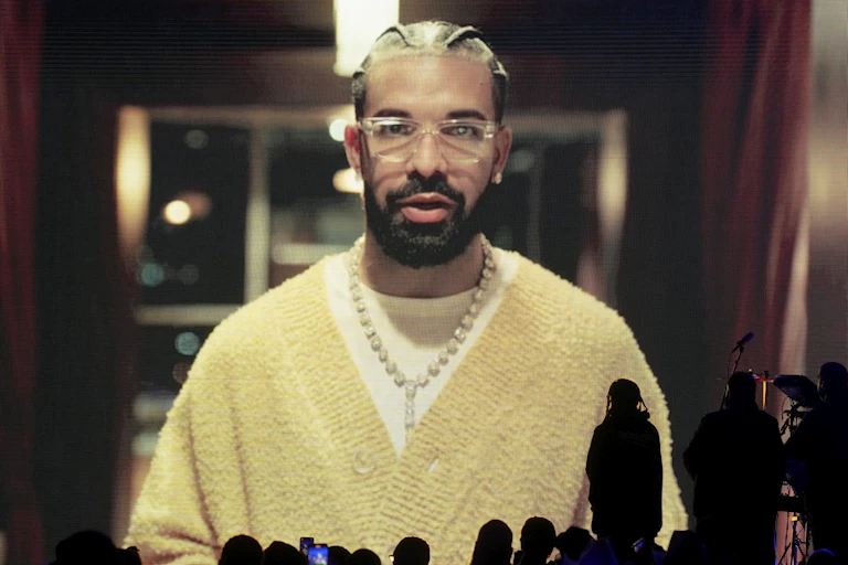 A man seen in a yellow sweater and transparent glasses.