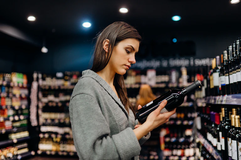 woman chooses bottle of wine
