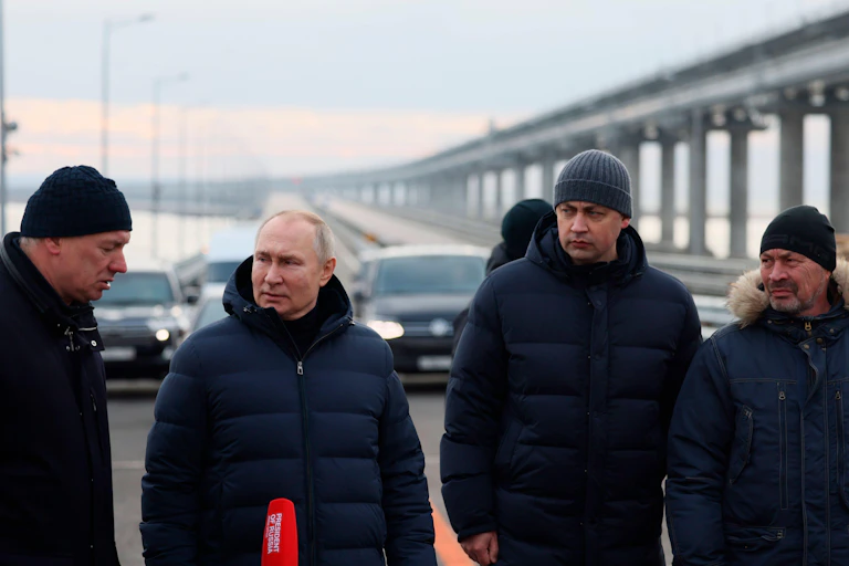Russian president Putin with the Kerch bridge in the background after an attack damaged the bridge.