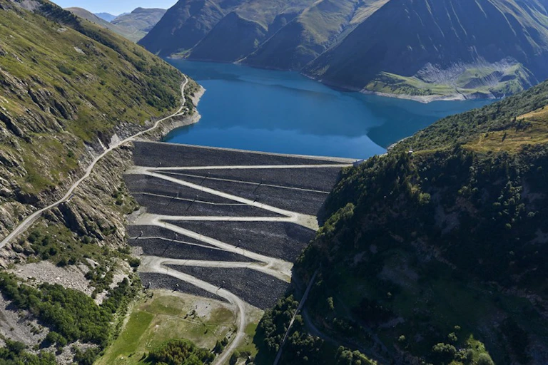 Barrage hydroélectrique retenant un lac de montagne.