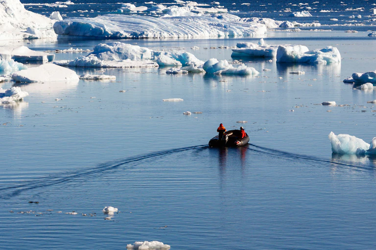 A small research boat surrounded by ice floes.