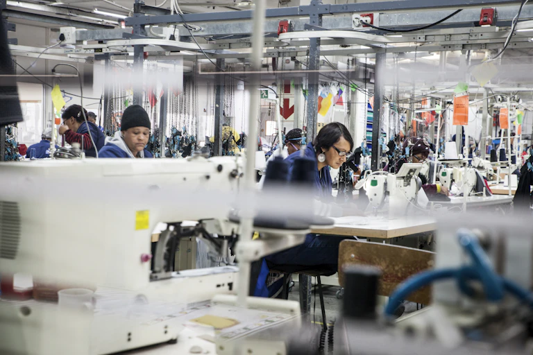 Women work in a factory with sewing machines at every table
