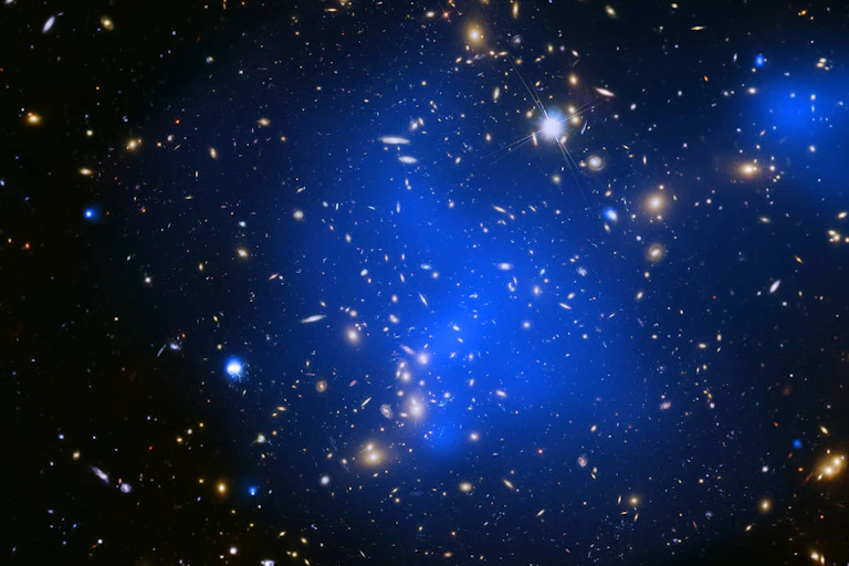 A cluster of many small, bright galaxies, surrounded by blue haze