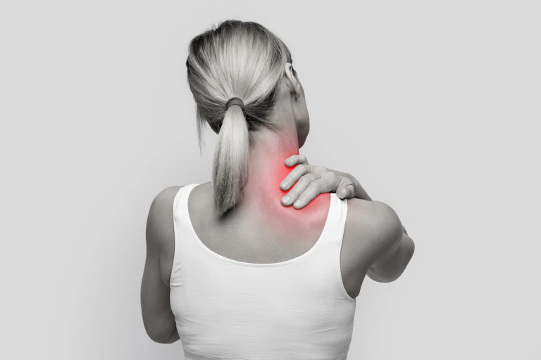 Stressed blonde woman massaging red sore neck