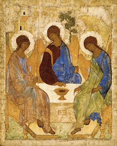 Three angels in a gold painting sat around a table.