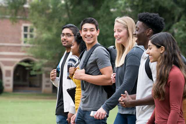 A group of college students walk on campus.