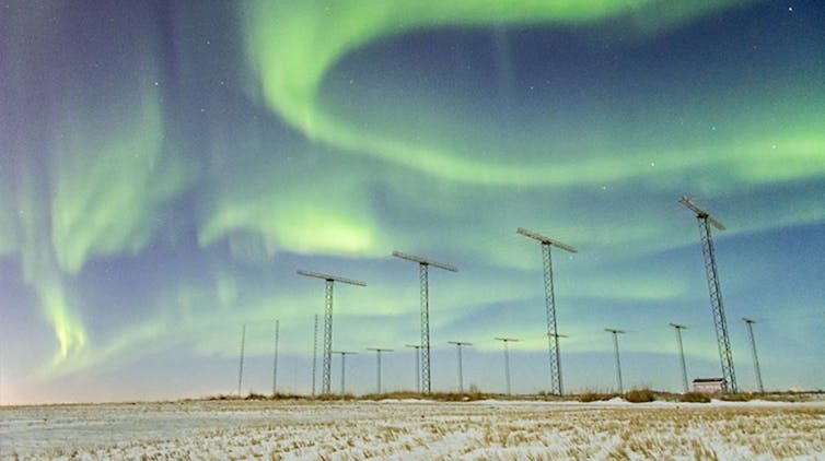 green lights ribbon in the sky above powerlines