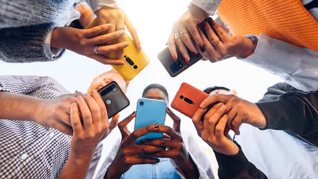 People standing in a circle holding phones
