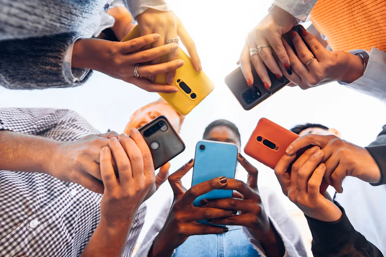 People standing in a circle holding phones