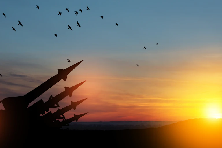 Four nuclear missiles aimed at the sky at sunset.