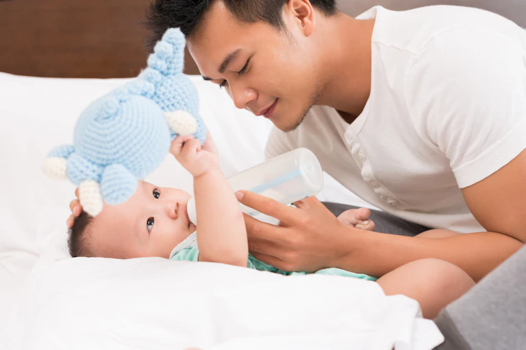 Father feeding baby from bottle