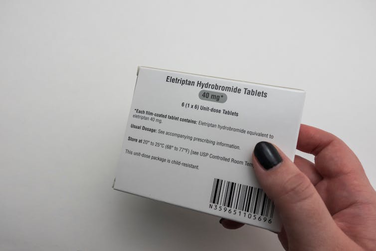 A hand holding a package of medication labelled eletriptan hydrobromide tablets