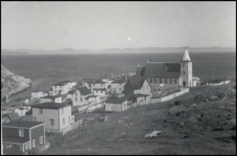 A black and white photo of a sea side town.
