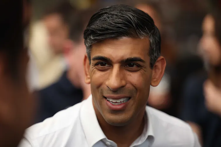 Headshot of Rishi Suank wearing open collar white shirt.